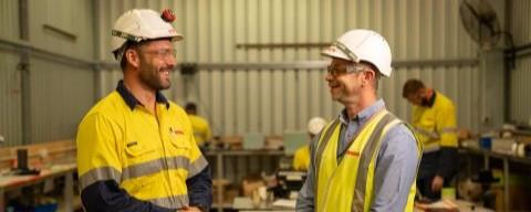 Two workers in protective gear on a worksite