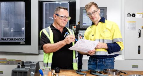 Two workers in protective gear on a worksite