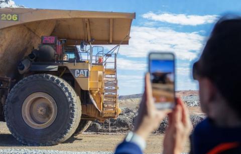 A lady using her mobile to take a photo of a large mining truck in Kalgoorlie-Boulder.