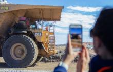 A lady using her mobile to take a photo of a large mining truck in Kalgoorlie-Boulder.